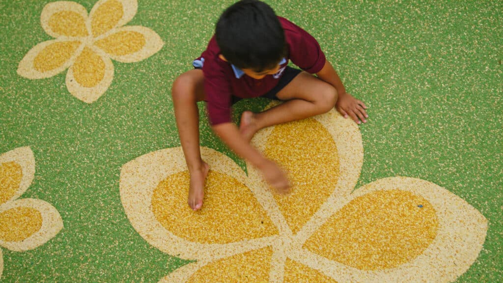 Flower playground surface and child playing on it.