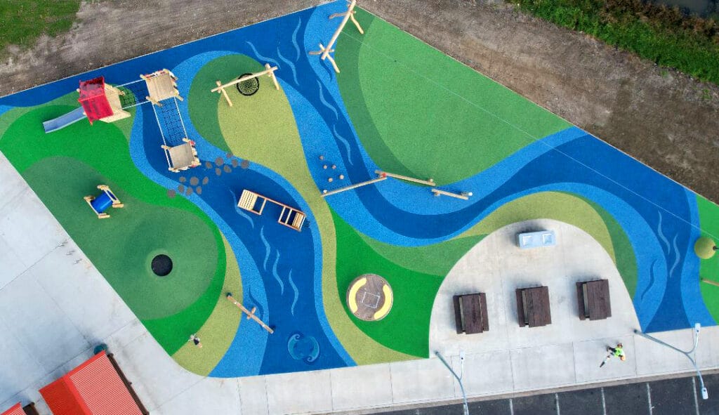 Aerial view of playground with blue, green and a river on the side