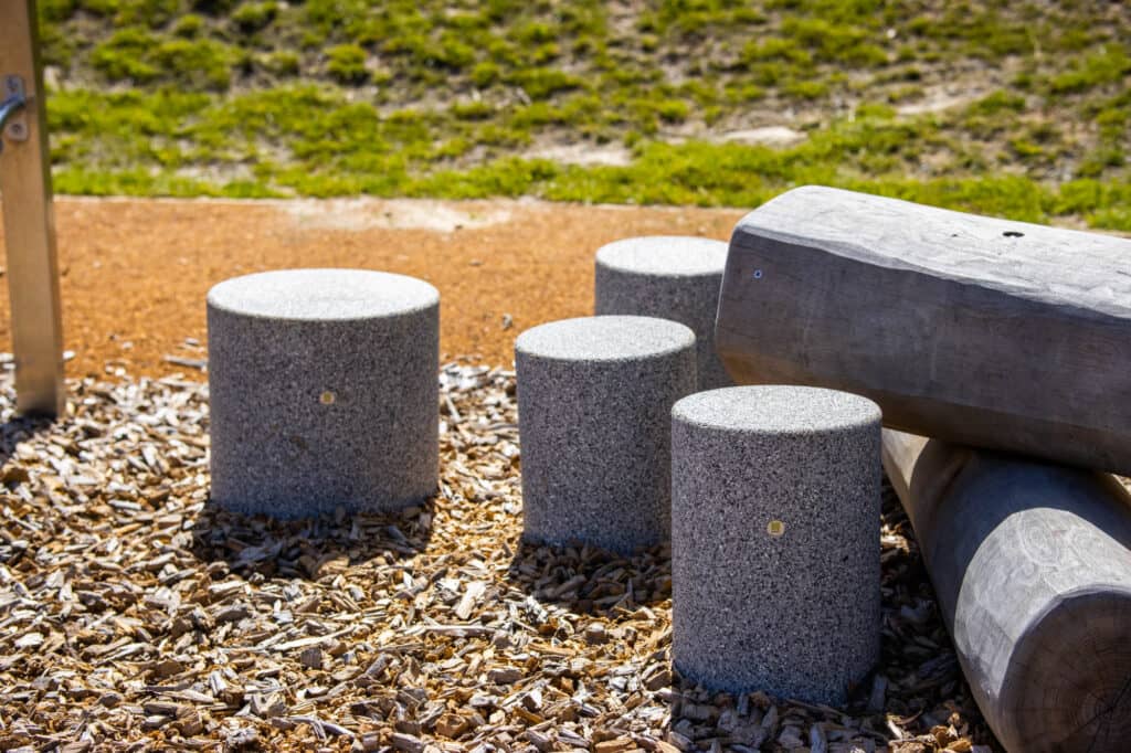Playground surface with different material, some pillars in gray.