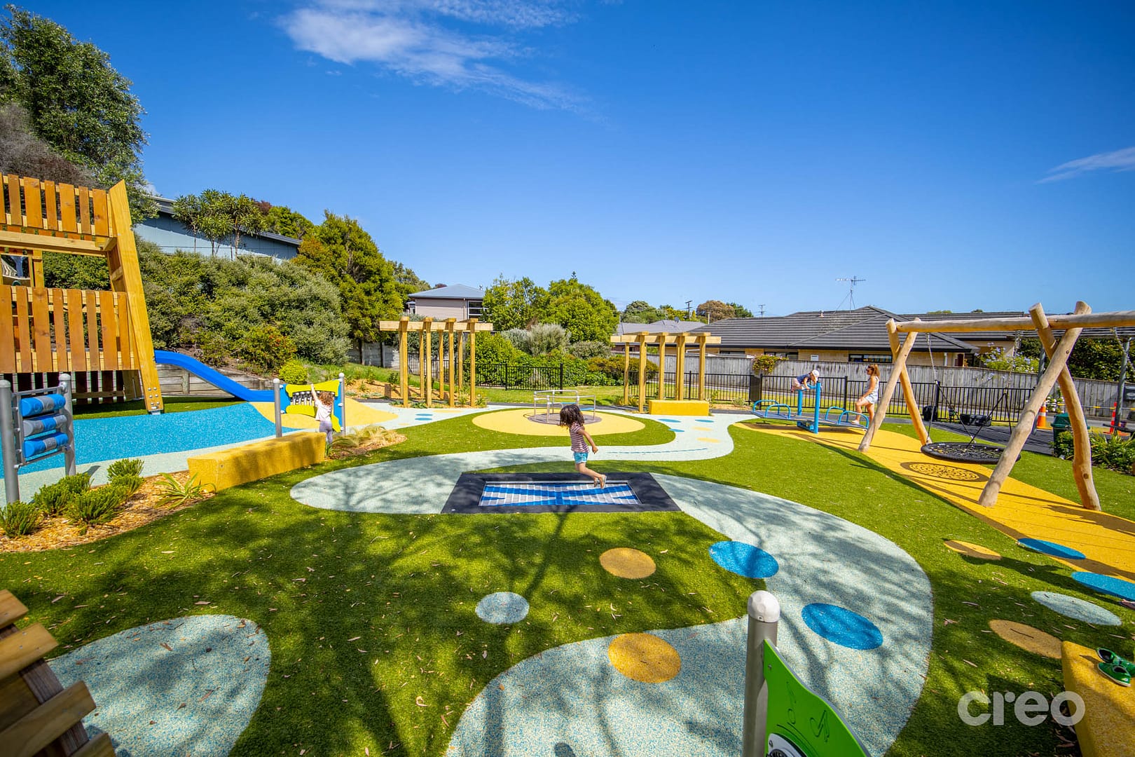 Child jumping on an inclusive ground trampoline in a playground
