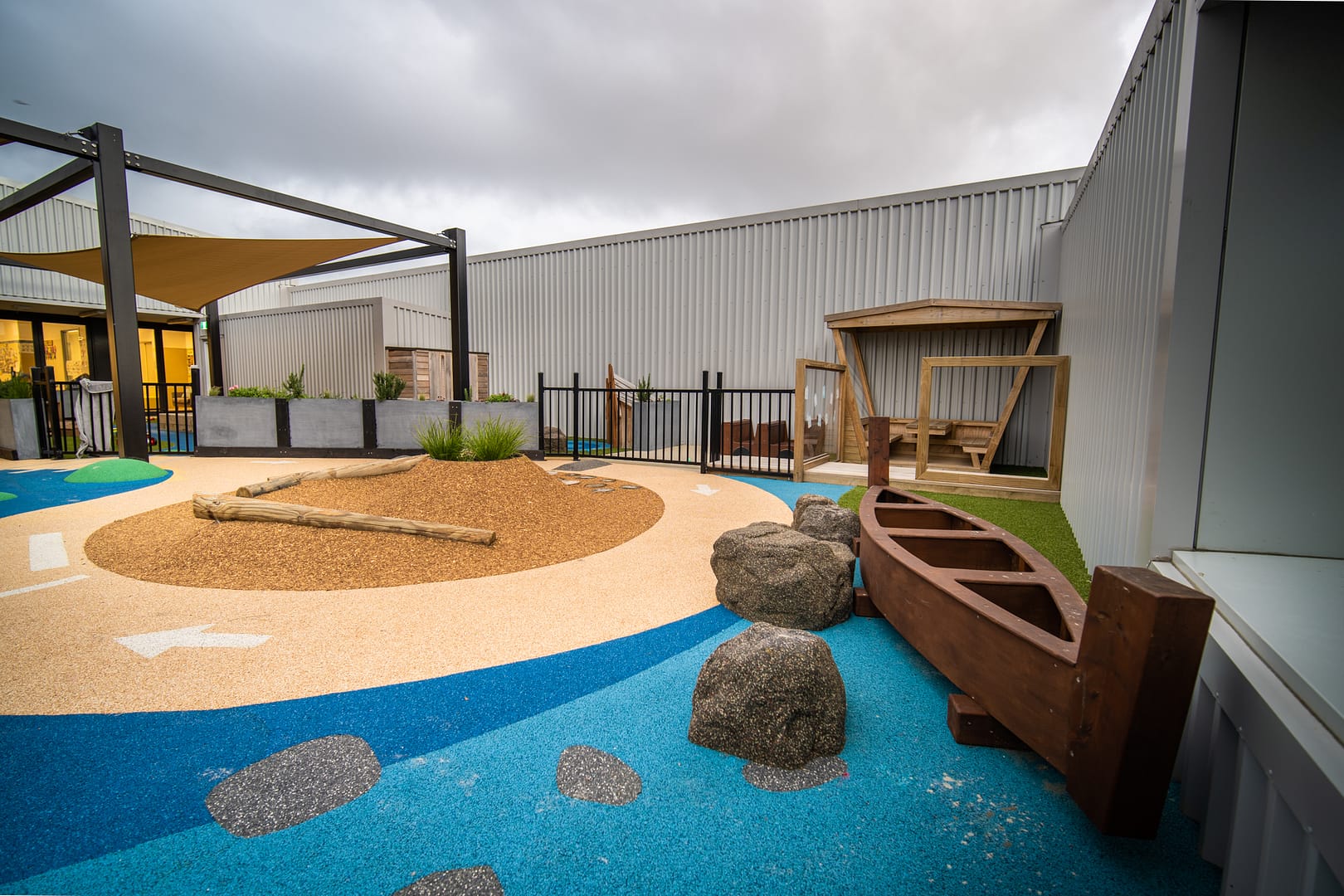 School playground with boat, blue and beige surface.